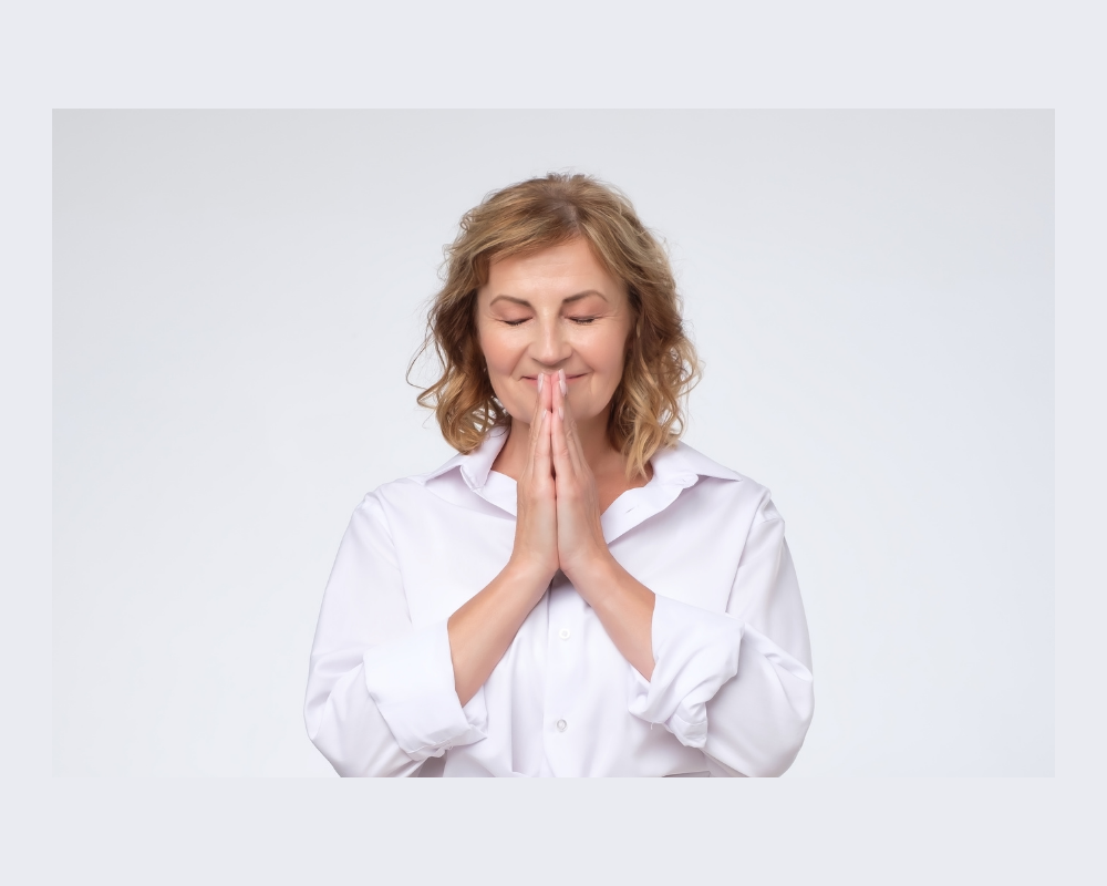 Woman with hands in prayer position feeling content